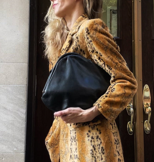 Late 80s black smooth leather shoulder bag, no hardware, structured silhouette, worn with fur coat — BB Vintage by Maxine