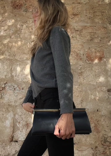 Vintage navy leather frame clutch, gold bar hardware, carried at side